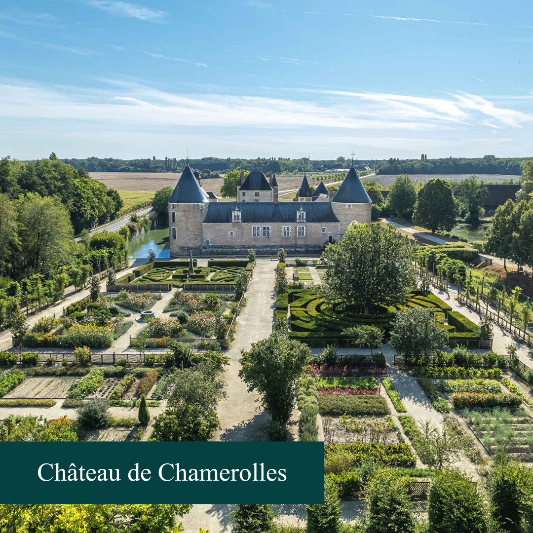 chateau avec un toit en ardoise et un parc en herbes devant avec un banc 